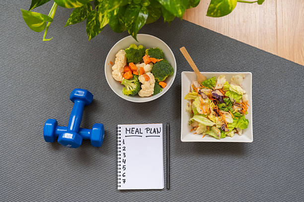 istock Meal plan and healthy eating concept with vegetables, salad, notepad, dumbbells and copy space for nutrition control, weight management and balanced lifestyle. 2237451922