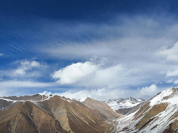 istock Magnificent Scenery of Snow-Capped Mountains Under a Blue Sky with White Clouds 2237455952
