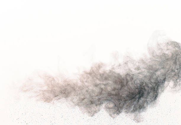 An abstract image showing black powder particles scattered on a white background, creating a visually striking effect with various shades and textures.