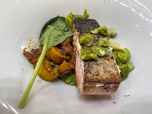 A Gourmet Dish Featuring Salmon Prepared with Fresh Seasonal Vegetables and Aromatic Herbs