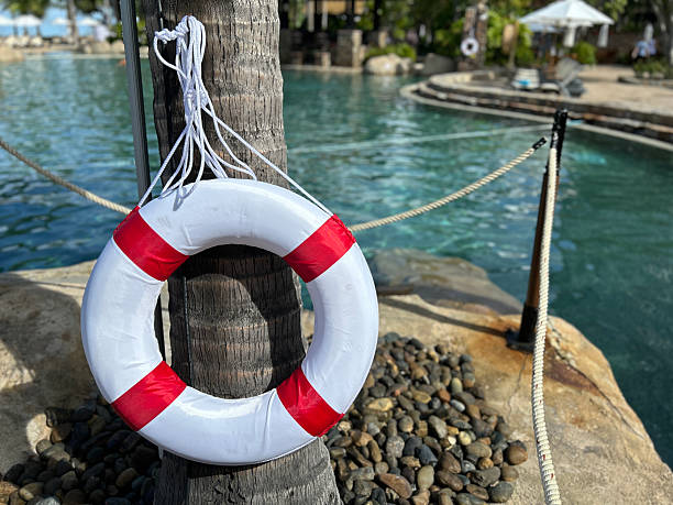 istock A red and white lifebuoy hangs on a tree by a swimming pool 2237463995