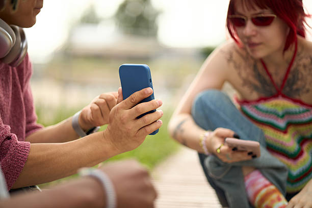 istock Young Multiethnic Friends Using Smartphones Outdoors during Summer Day 2237468176