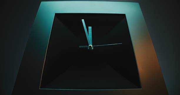 Close Up of Square Wall Clock with Futuristic Design on Blue Background with Moving Clock Hands Showing Precise Time. Modern Interior Decoration. Concept of Punctuality, Time Management and Lifestyle.