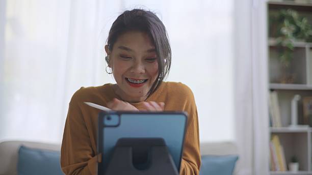 istock Excited Asian Professional Using Digital Tablet and Celebrating New Business Opportunity. 2237472292