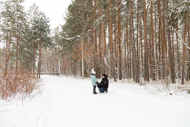 istock Dad and daughter walking and having fun in snowy winter forest 2237473072