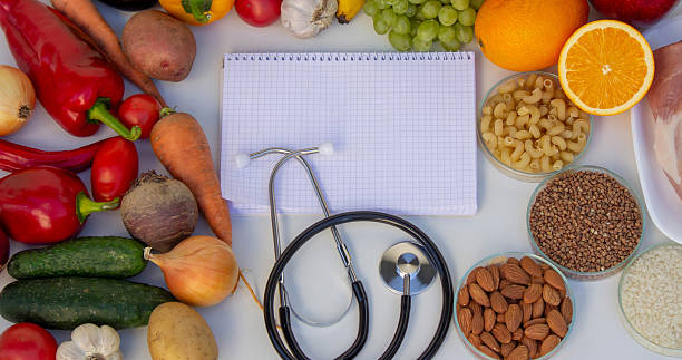 istock Diet Planning: Stethoscope, Notebook, and a Balanced Selection of Food 2237473458