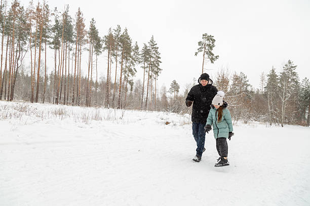 istock Dad and daughter walking and having fun in snowy winter forest 2237473709