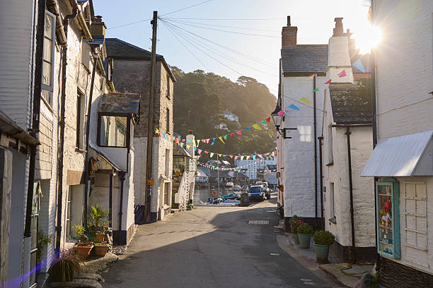 Polperro village and harbour cornwall, england, UK at high tide during a sunny day. Polperro on the south east coast of cornwall still has a busy working harbour mainly used by local fishermen and tourist boat trips, the quaint cottages are typical of cornish villages.