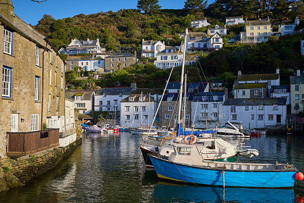 Polperro village and harbour cornwall, england, UK at high tide during a sunny day. Polperro on the south east coast of cornwall still has a busy working harbour mainly used by local fishermen and tourist boat trips, the quaint cottages are typical of cornish villages.