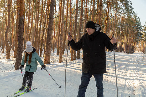 istock Dad and daughter skiing in the winter forest 2237474424
