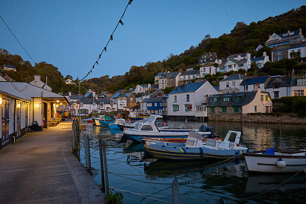 Polperro village and harbour cornwall, england, UK at high tide during sunrise. Polperro on the south east coast of cornwall still has a busy working harbour mainly used by local fishermen and tourist boat trips, the quaint cottages are typical of cornish villages.