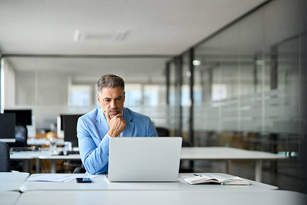 istock Busy middle aged professional business man using laptop in office. 2237477149