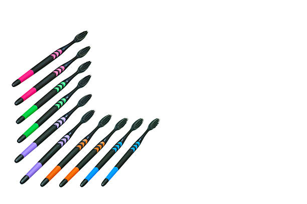 Hygiene.Black toothbrushes with colored inserts isolated on white