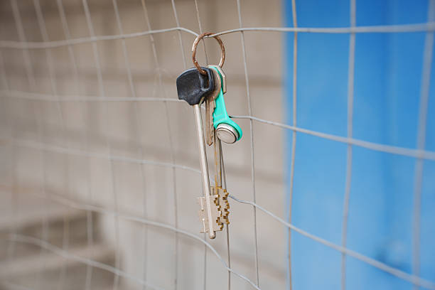 house shape keyring and house keys against yellow background