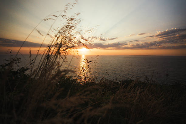 Dramatic sunset with rays of light breaking through the clouds over the Atlantic Ocean, captured from the northern coast of Asturias, Spain. A serene seascape highlighting the beauty of nature and the coastal Camino de Santiago.