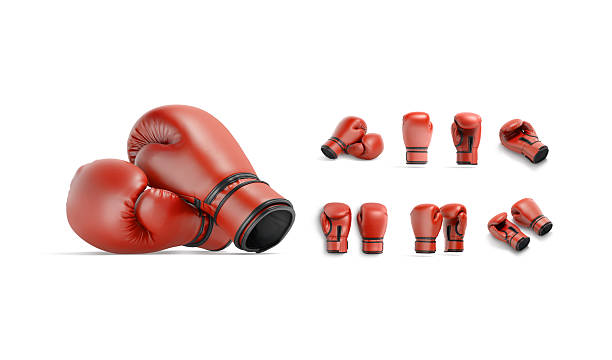 Blue boxing gloves and red protective headgear lying on the canvas floor inside a boxing ring. Sport equipment for training