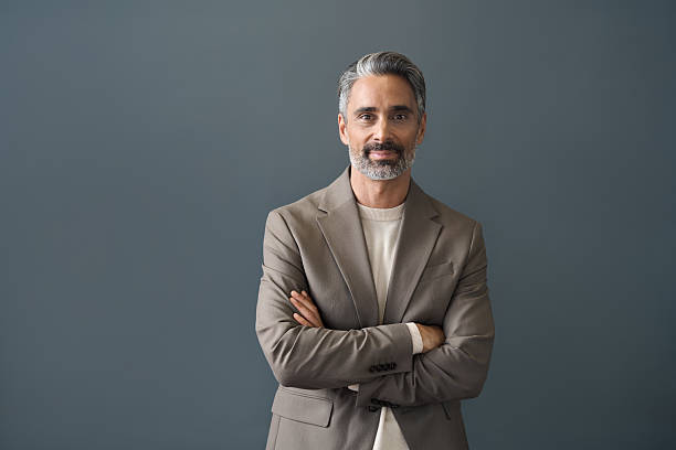 istock Happy middle aged business man looking at camera standing at gray background. 2237489906