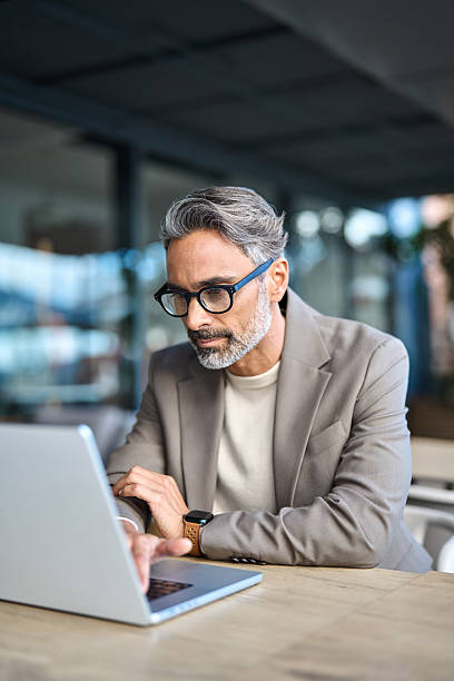 istock Busy older business man hybrid working outdoors using laptop. Vertical. 2237489957