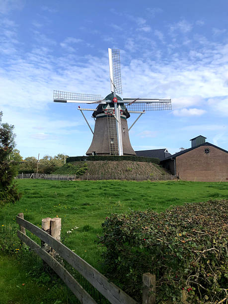 istock Traditional Dutch windmill in a green field under a blue sky 2237490217