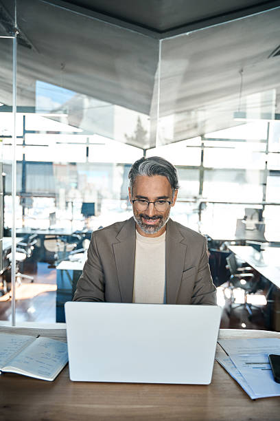 istock Happy busy middle aged business man using laptop computer in office. Vertical 2237491150