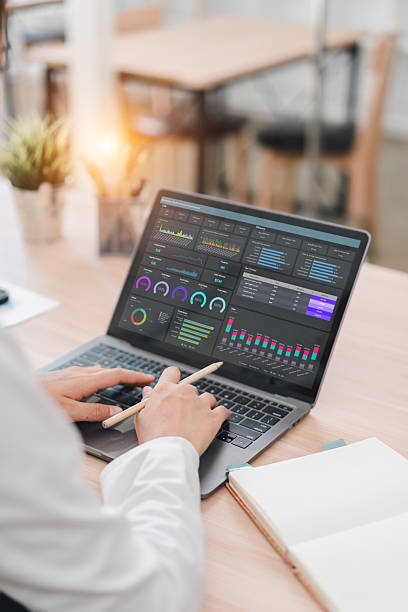 istock Business professional working on laptop with data analysis dashboard showing graphs and charts, modern office environment, focused and productive atmosphere 2237494015