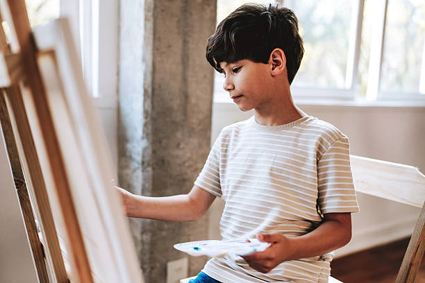 istock Boy painting on canvas during art class 2237495155