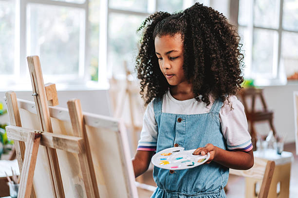 istock Black girl painting on canvas during art class 2237495294