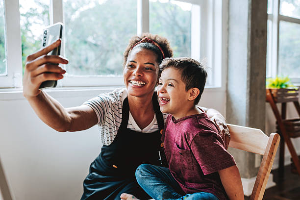 istock Art teacher taking selfie with boy with Down syndrome during painting class 2237495560