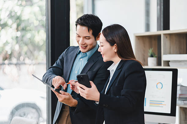 istock Business professionals discussing data on digital tablet, smiling and collaborating in modern office with natural light, teamwork and technology concept 2237495856