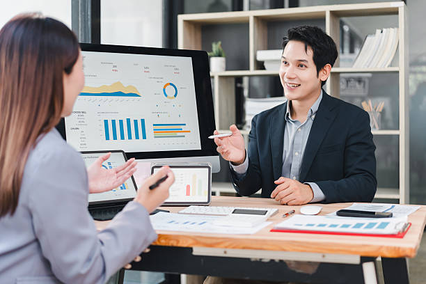 istock Business dashboard presentation with two Asian colleagues discussing data analysis and financial charts in modern office, showing teamwork and positive collaboration for project success 2237495958