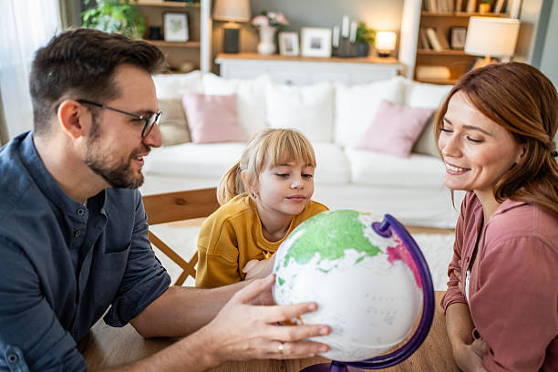 istock Parents and child learning geography with globe at home 2237498166
