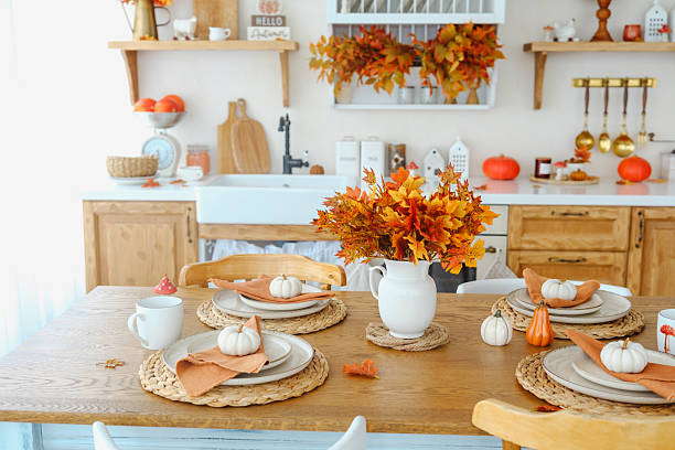 istock Autumn dining table setting with pumpkins and maple leaf bouquet. Natural wood surface. 2237511080