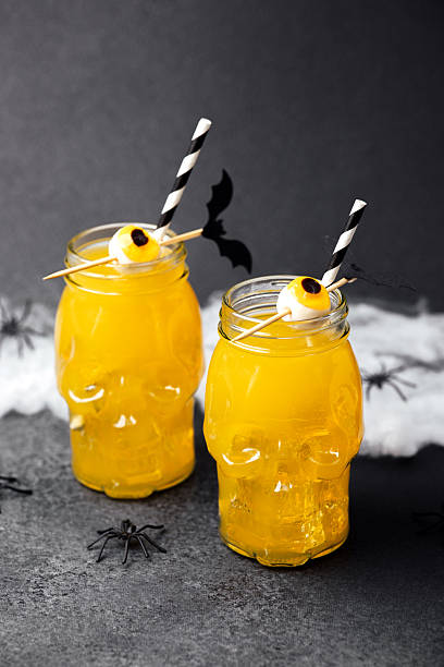 istock Spooky skull drinks with eyeball garnish and bats, Halloween party beverages on dark table. 2237512544
