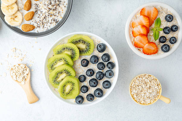 istock Oatmeal breakfast bowls with fruits and grains on white surface 2237512673