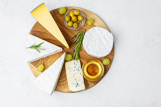 istock Cheese platter with assorted cheeses, olives, honey, and grapes 2237512922