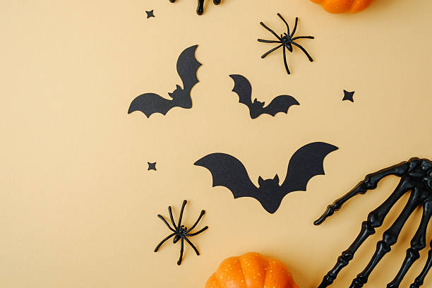 istock Halloween decorations bats spiders skeleton hand and mini pumpkins on pastel background top view 2237512945