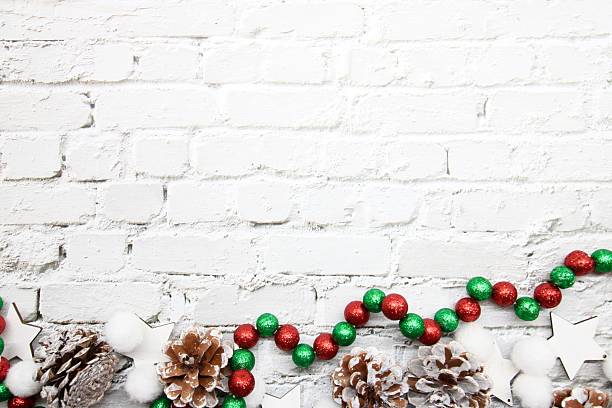 istock Red decorative Christmas baubles against white brick wall, festive holiday decor emphasizing seasonal spirit and classic ornament style 2237515349