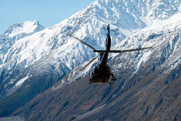 An Inflite Airbus Helicopters H130, registration ZK-IZI, taking off from Mount Cook Airport and heading up the Tasman Valley with tourists on a flight around the southern alps of the South Island. In the background are snowcapped mountains of the Mount Cook Range. This image was taken on a cold, windy and sunny afternoon on 11 September 2025.