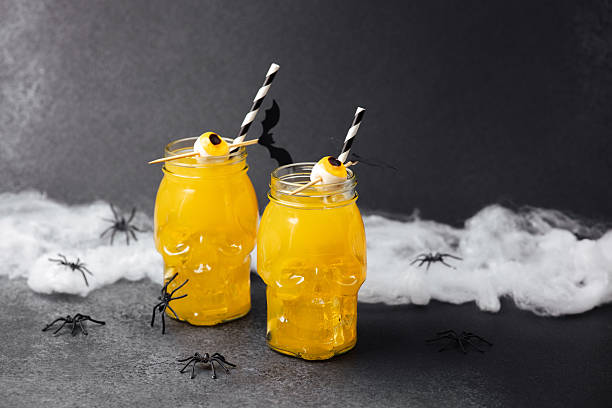 istock Two spooky Halloween drinks in skull jars with eyeball garnish, spider webs, and plastic spiders. 2237521058