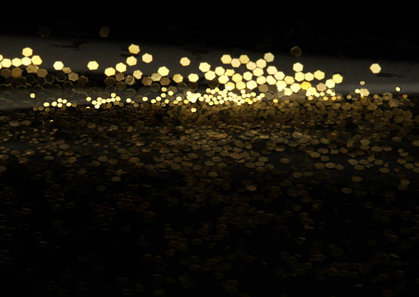 Blur soft focus Gold (bronze) glitter shine dots on black. Abstract light blink sparkle horizontal backgound.