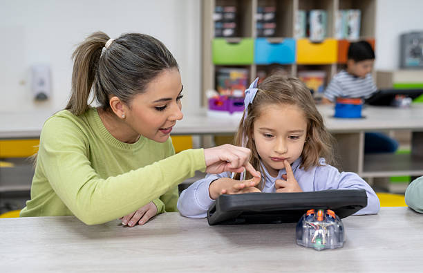 istock Teacher teaching a girl to code in a STEM class at the school 2237526658