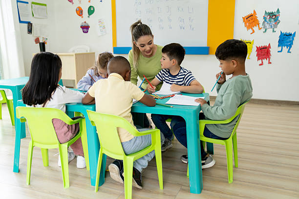 istock Primary school teacher watching children coloring in her class 2237526766