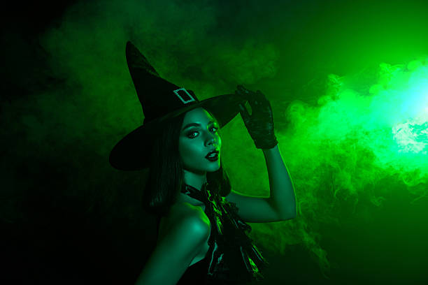 istock Mysterious witch in green haze casting a spell in Halloween attire with a pointed hat showcasing her enchanting beauty. 2237526801