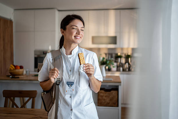 istock Healthcare worker eating granola bar on break at kitchen 2237526901