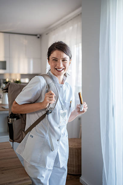 istock Happy female nurse smiling with backpack leaving home for work 2237526916