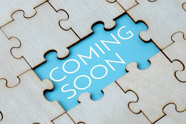 istock A wooden puzzle with a missing piece, revealing a blue background with the text COMING SOON. 2237535007