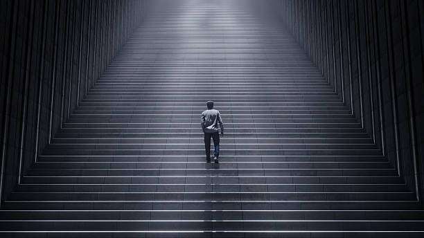 istock Man Walking Up Long Wide Steps Toward Light - Symbol of Perseverance, Ambition, and Success 3D Render 2237536385