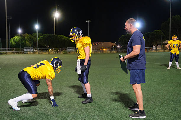 istock American football coach instructing players during night practice 2237536430