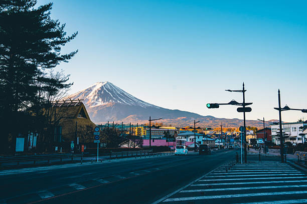 Mount fuji rising above a town with a road and crosswalk in japan