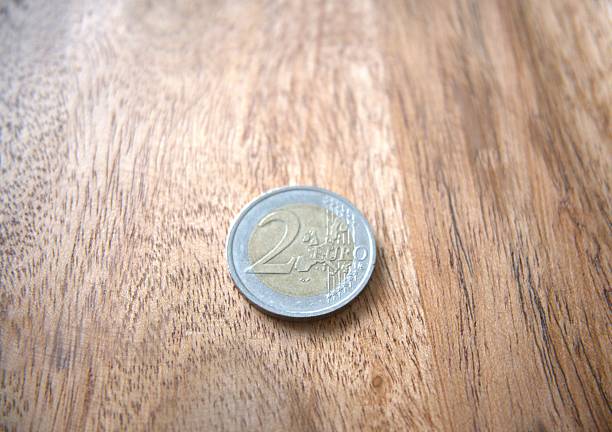 istock Two euro coin on wooden table, close-up, copy space 2237538825